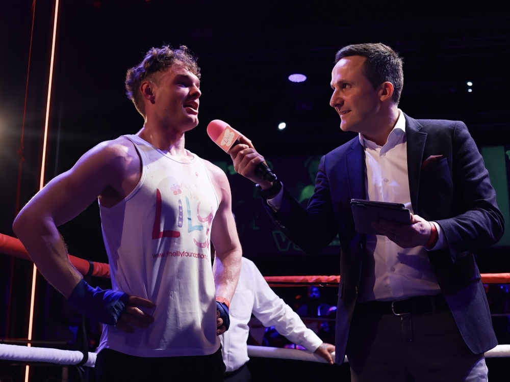 A Lily Fight Night boxer being interviewed by commentator Adam Leventhal