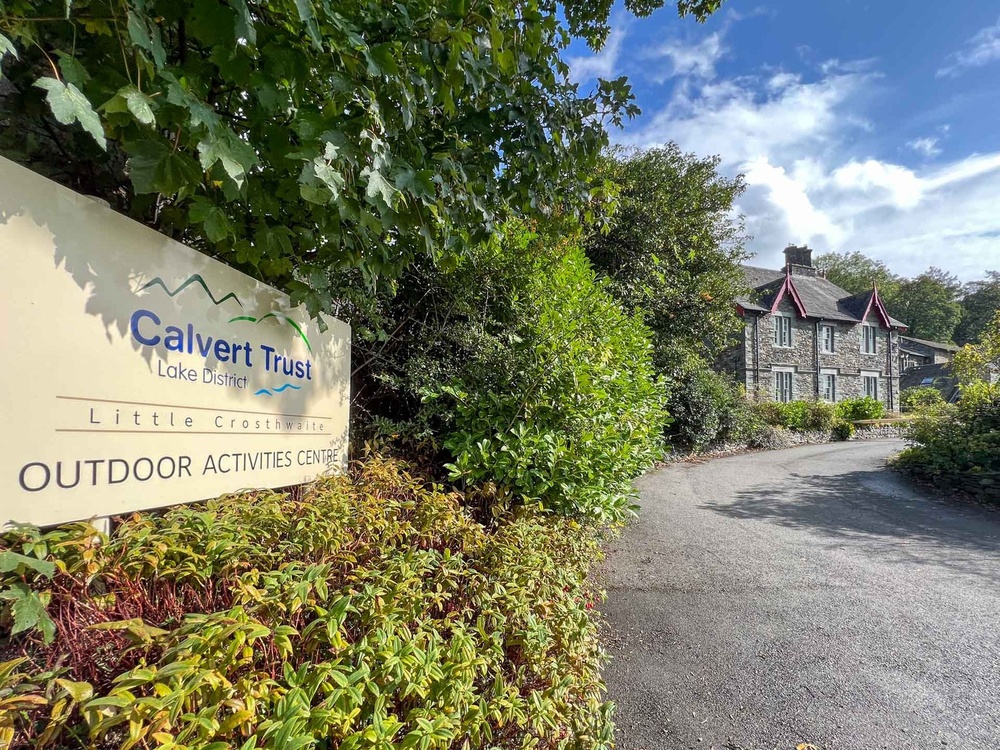 A driveway with a 'Calvert Trust' sign and a building in the distance