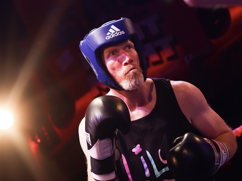 Close-up of a boxer in a Lily vest  and headguard at the Lily Fight Night