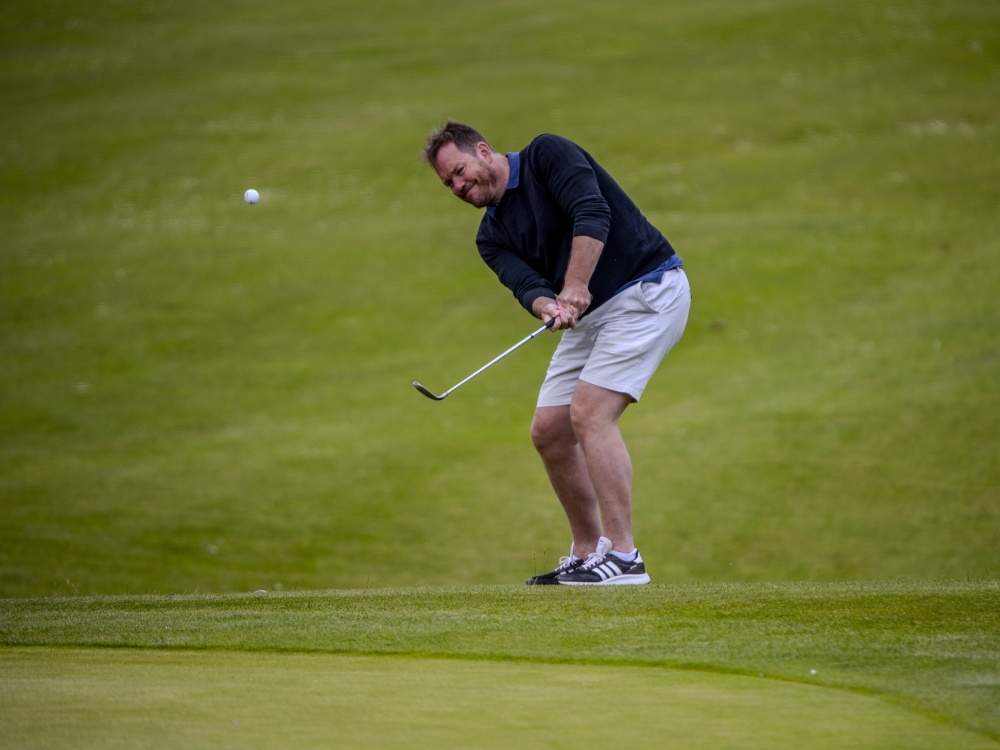 A man swinging a club on a golf course