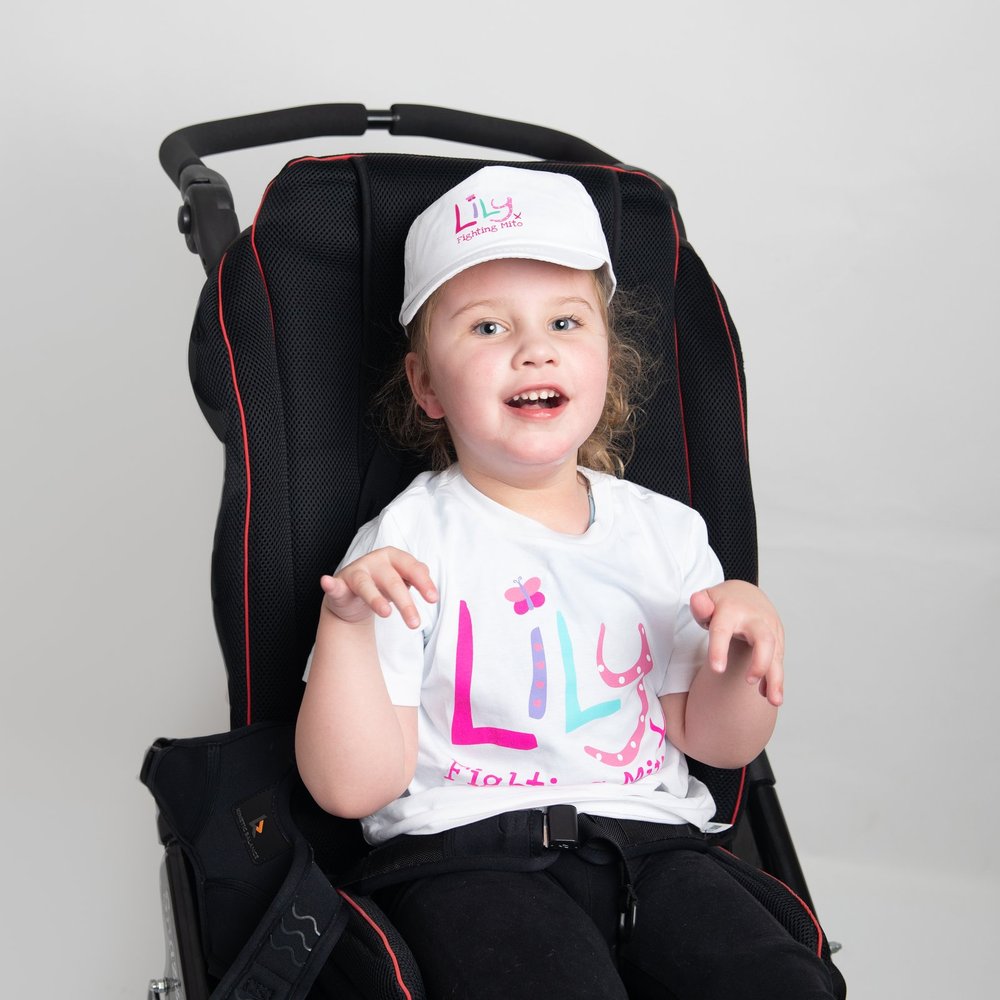 a young girl wearing a white baseball cap featuring the Lily Foundation logo and the words fighting mito.