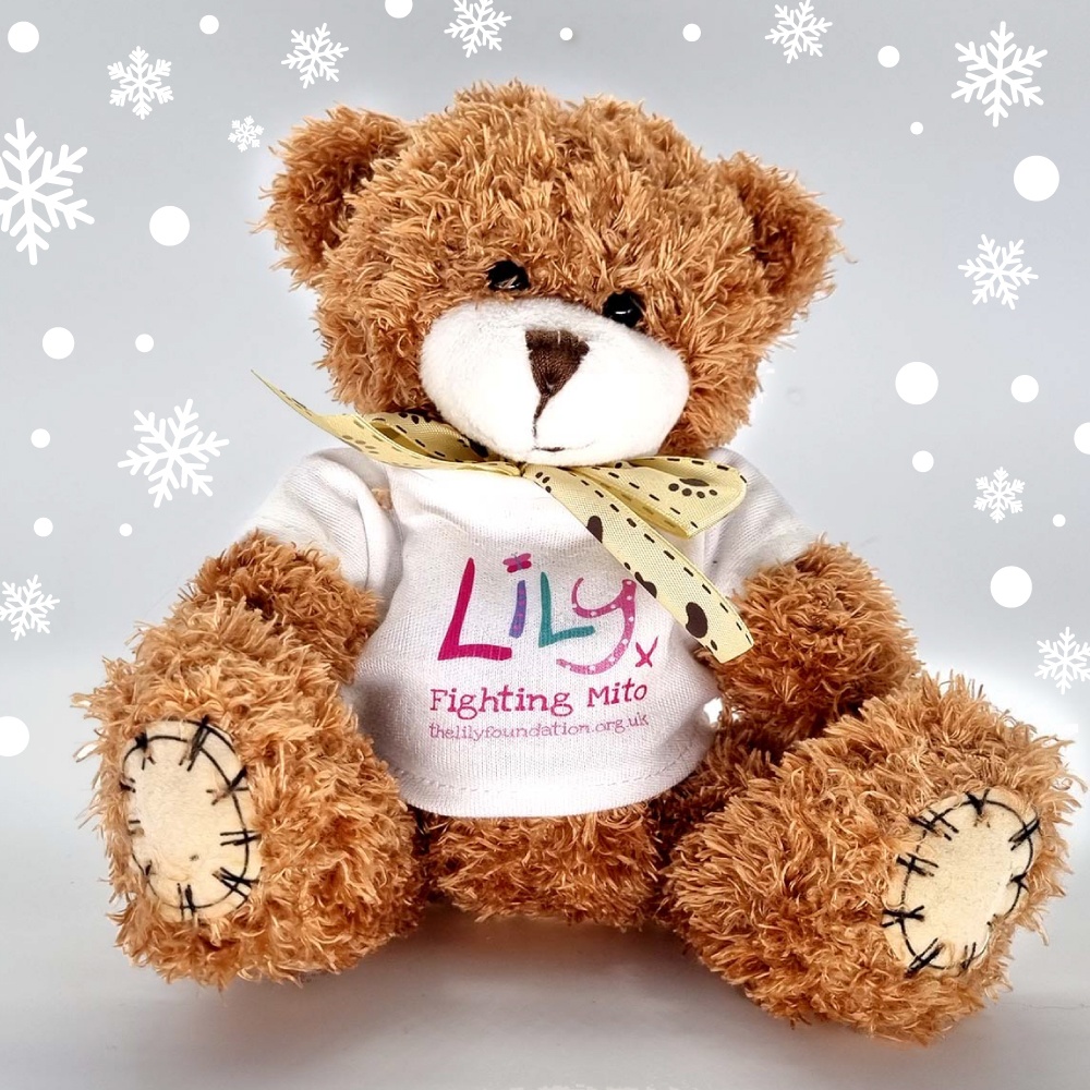 A brown teddy bear with a bow and a white t-shirt featuring the Lily Foundation logo and the words fighting mito.