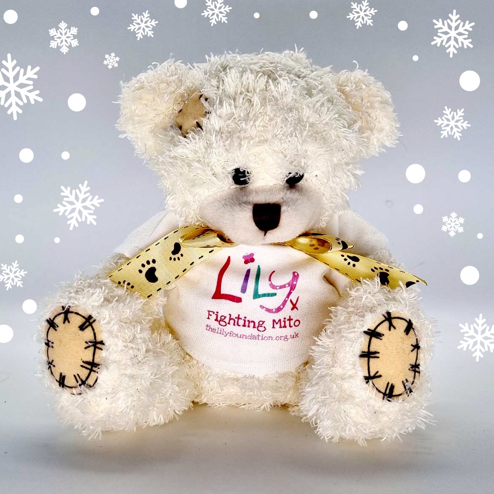 A white teddy bear with a bow and a white t-shirt featuring the Lily Foundation logo and the words fighting mito.