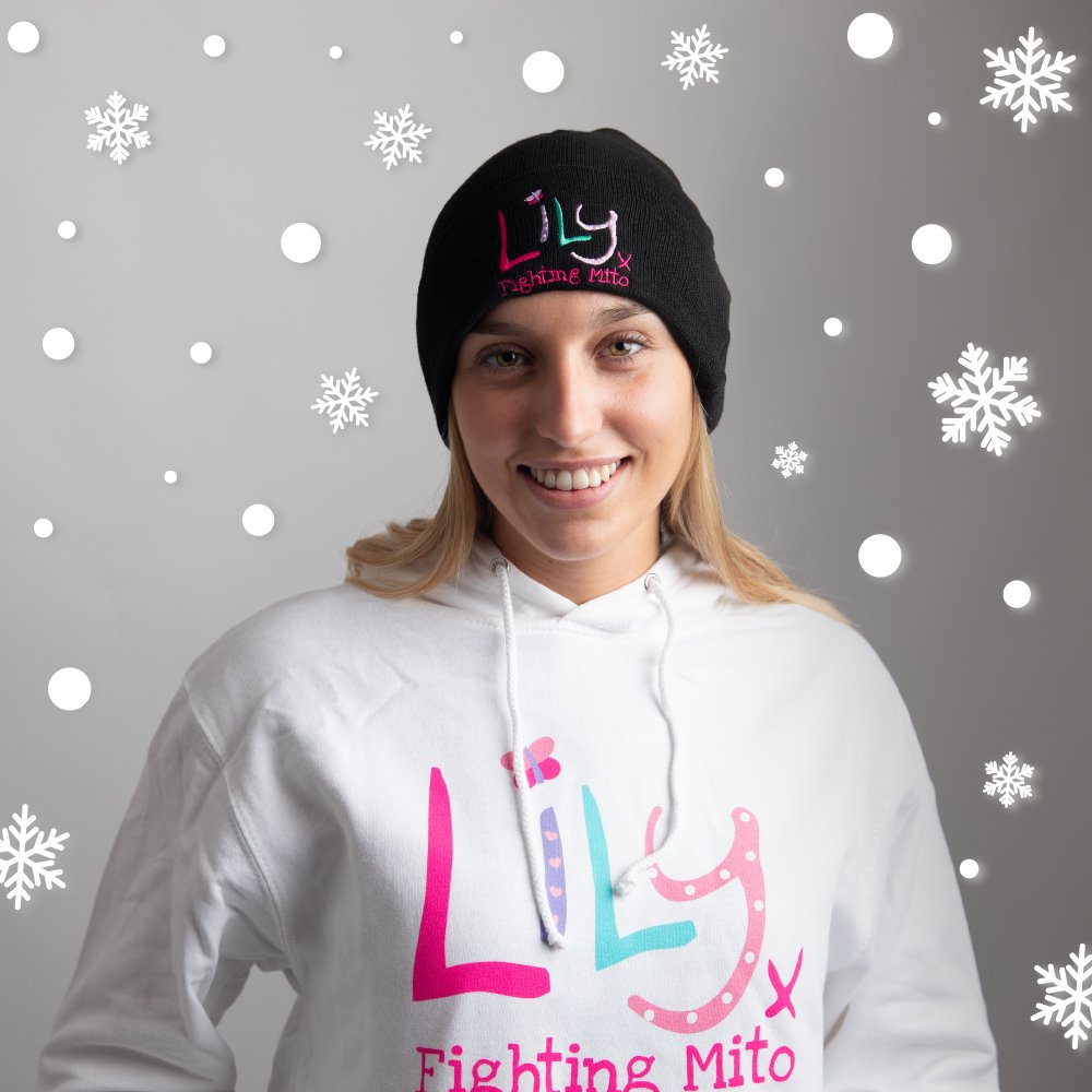 A woman in a black beanie hat featuring The Lily Foundation logo and the words fighting mito.