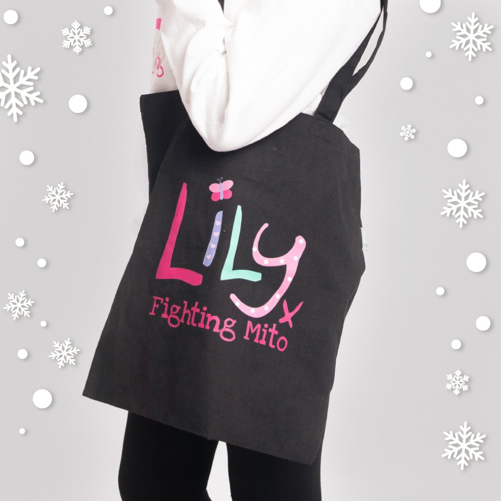 a black cotton bag featuring the Lily Foundation logo and the text fighting mito over a girl's shoulder.