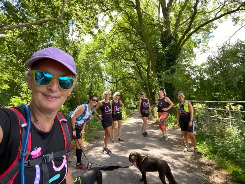 A group of women in Lily tops smiling on a shady tree-lined country lane