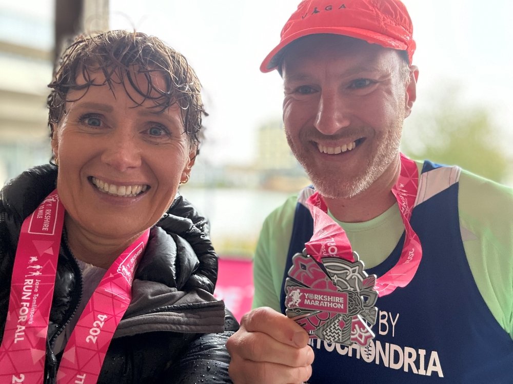 Yorkshire Marathon 2025 - Two mito parents proudly holding their Yorkshire Marathon medals up and smiling