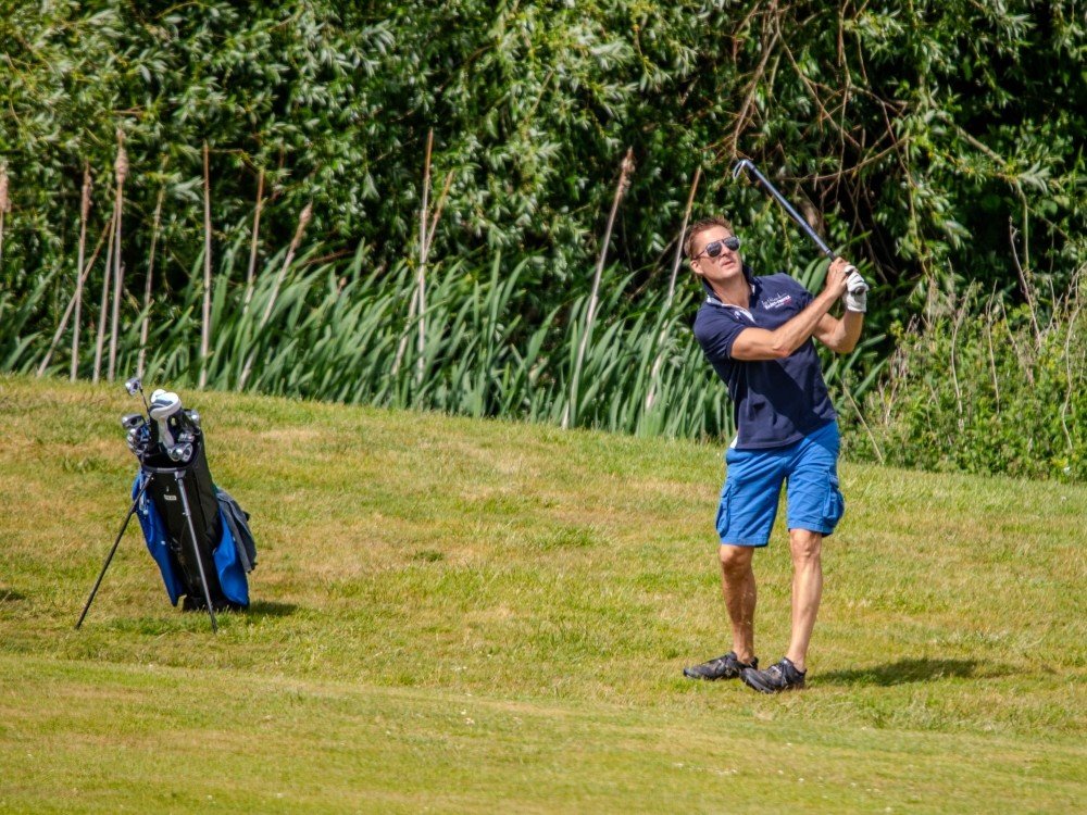 A man on the green swinging a golf club at the Lily Foundation golf day A man on the green swinging a golf club at the Lily Foundation golf day
