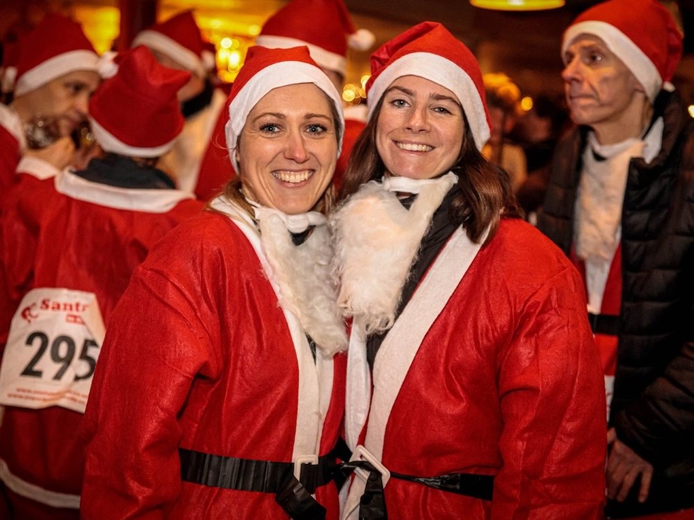 Santa in the City Tunbridge Wells 2024 - Two ladies dresses in Santa suits laughing at the Santa in the City Tunbridge Wells event