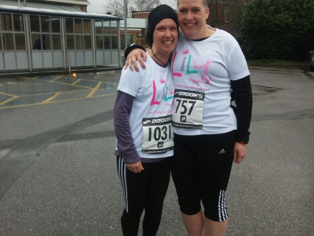 Two women wearing Lily Foundation running tops and standing together