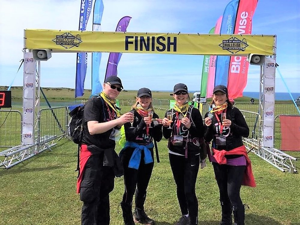 Ultra Challenge Series – 16 great events to choose from in 2024 - Four Ultra Challenge competitors standing at a finish line with glasses of fizz