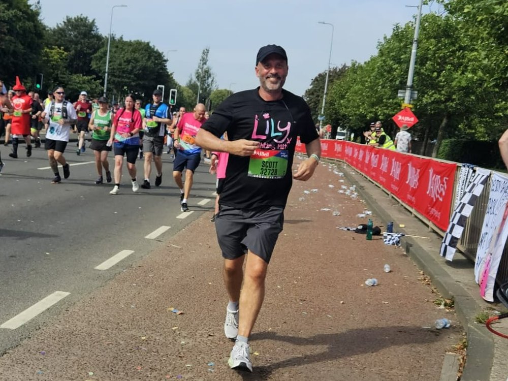 Great North Run 2025 - A man in a Lily Foundation t-shirt running along the road at the Great North Run