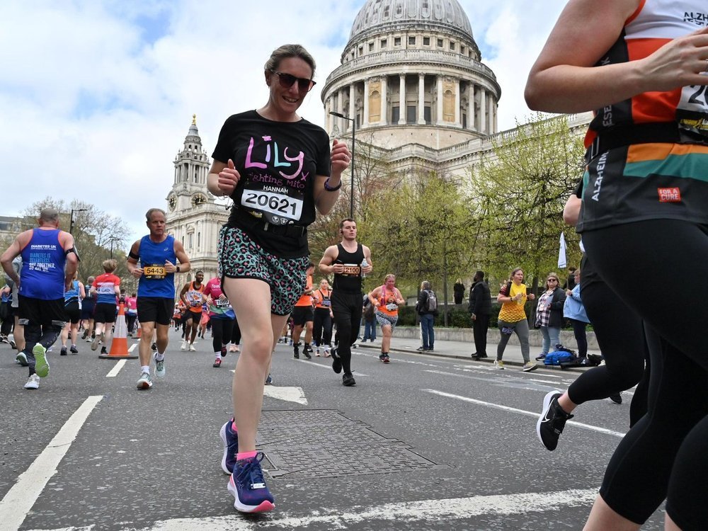 A woman in a Lily t-shirt running past St Paul's Cathedral in London