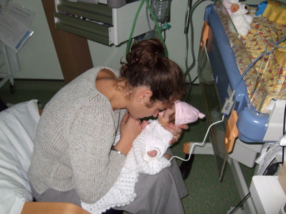 Liz holding baby Lily in a hospital as she is diagnosed with mitochondrial disease