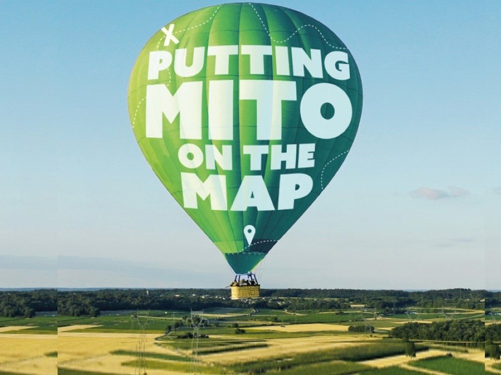 Hot air balloon floating in the sky with 'Putting mito on the map' logo on