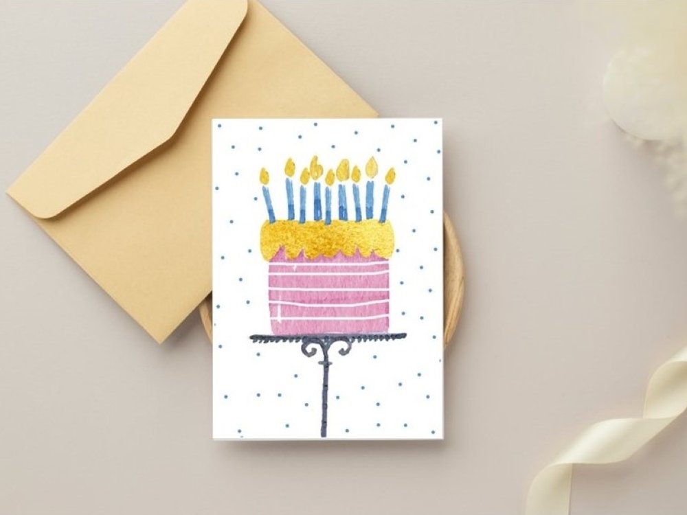 Birthday card featuring a cake and candles on a surface