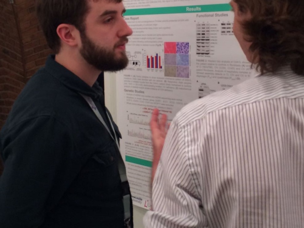 Two men standing looking at a large poster