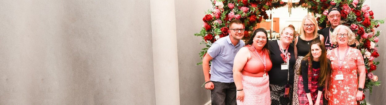 A group of people standing together below a large display of flowers