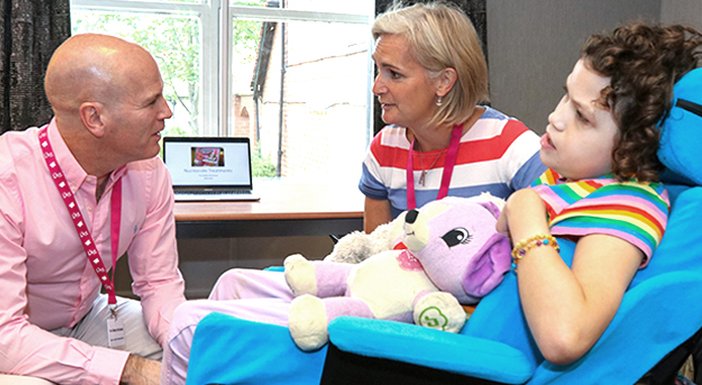 Professor Bobby McFarland from Newcastle University talking to a mum and her daughter, who has mito,