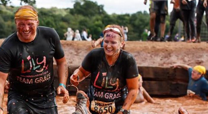 Four Lily Fundraisers, laughing, covered in mud at a Tough Mudder event