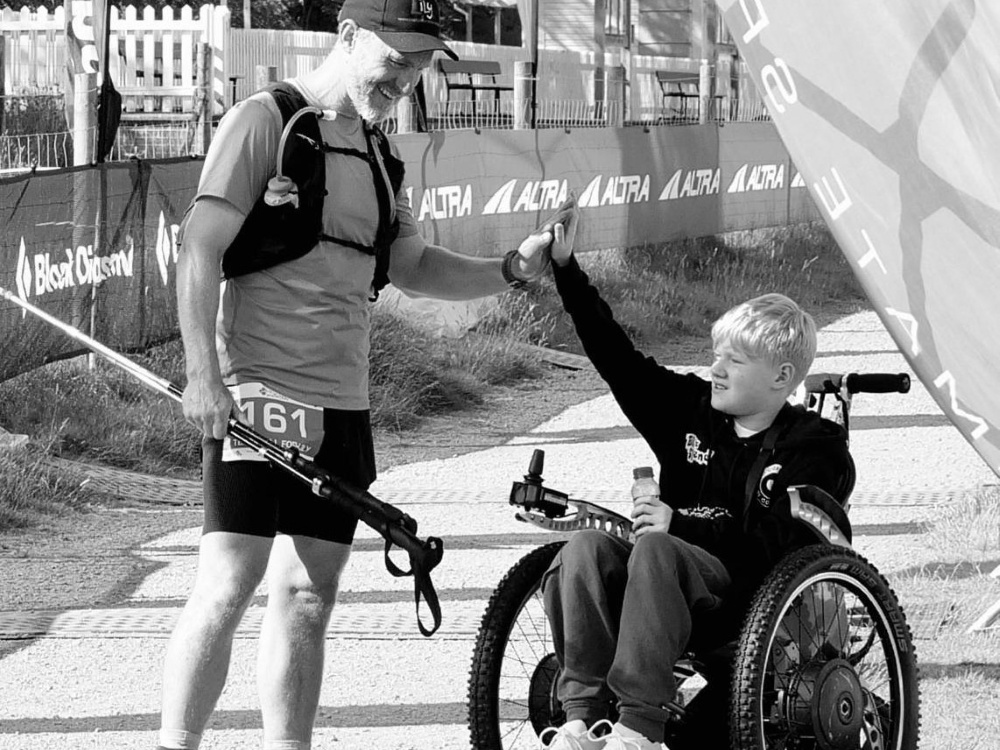 Dad Sid greeting son Bill in his wheelchair on completing the Snowdonia Ultra Challenge