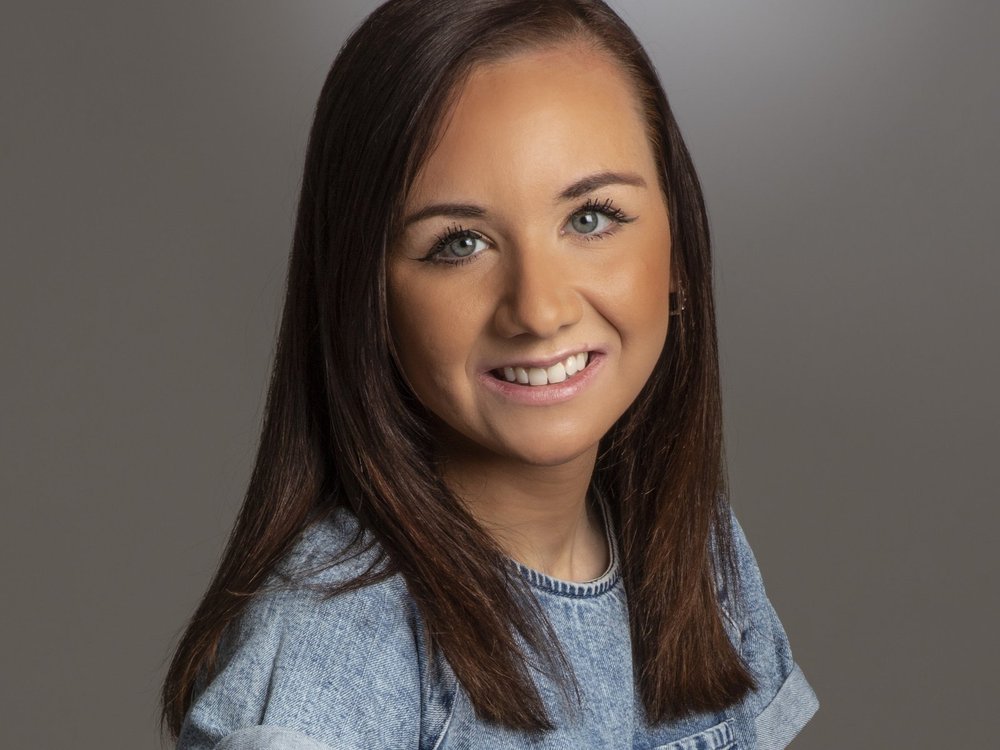 A head shot of a smiling woman with shoulder length brown hair