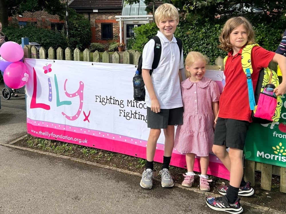 Young mito warrior Bill with his 2 siblings in front of a Lily banner at school