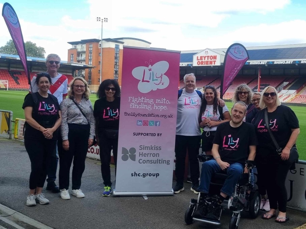 Kevin and supporters standing outside Leyton Orient with a Lily banner