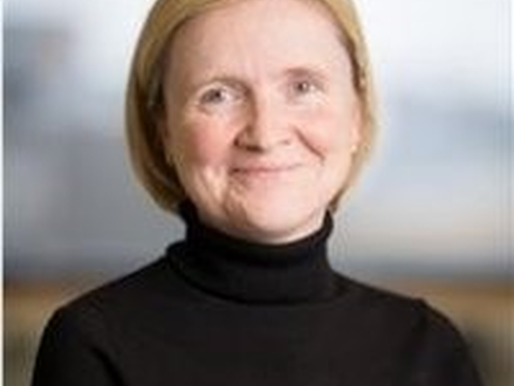 A head shot of a smiling woman with a short blonde bob