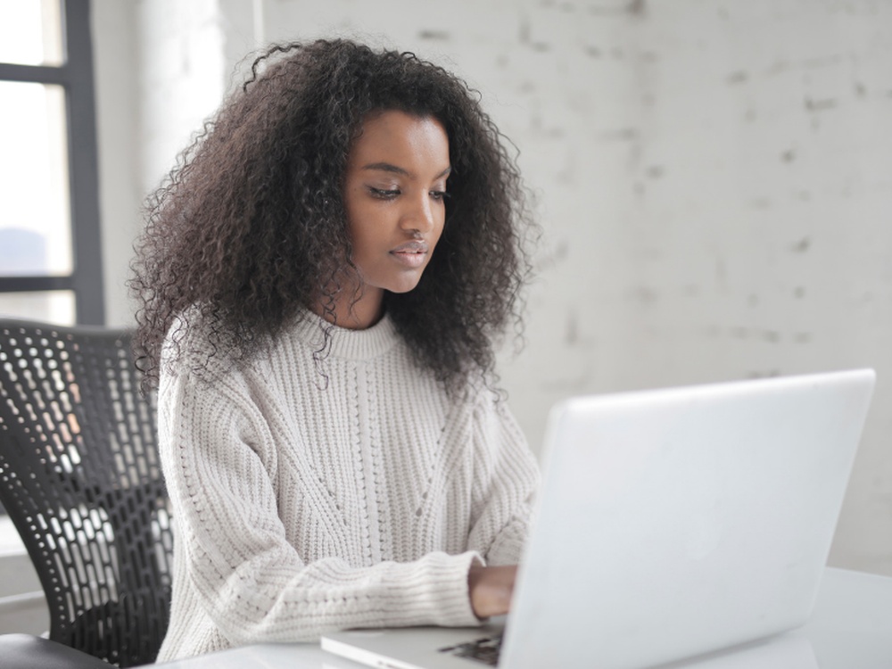 A young women sitting at a desking working on a computer