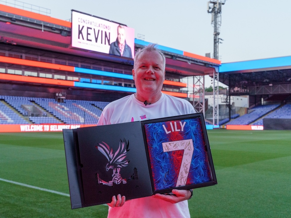 Kevin at Selhurst Park holding a framed signed Crystal Palace shirt