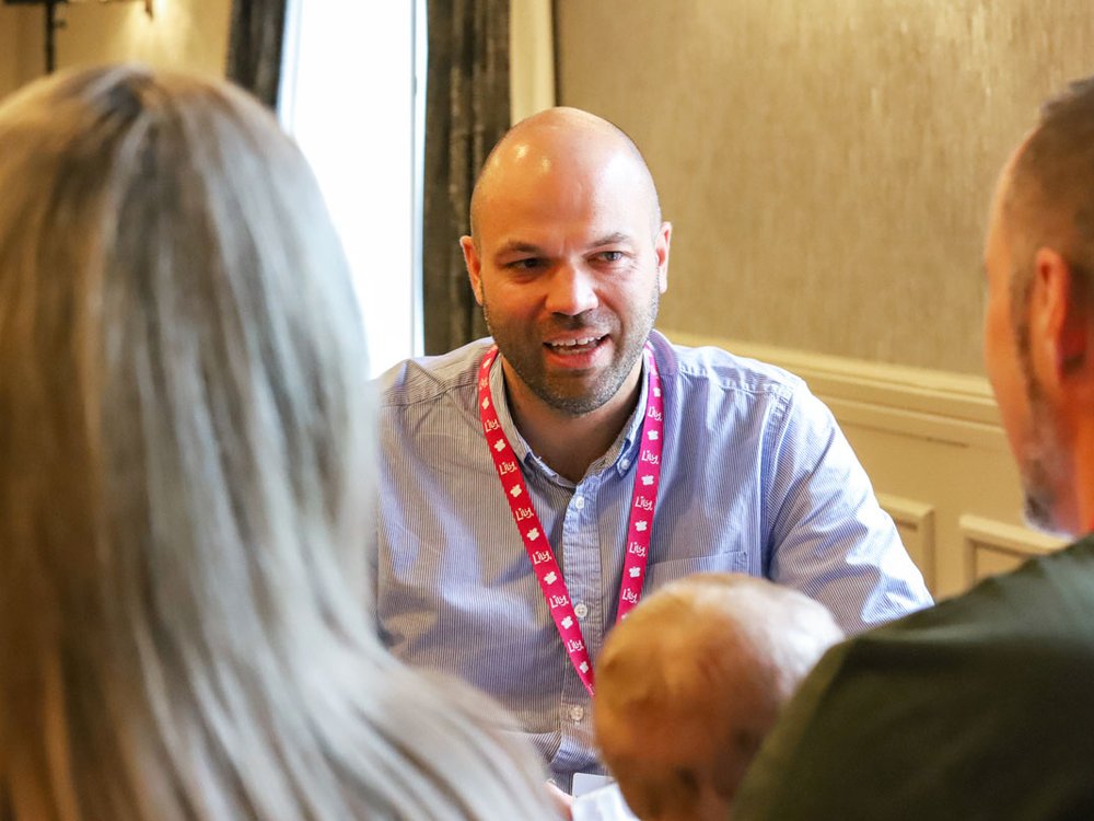 A researcher talking to a couple with a young baby