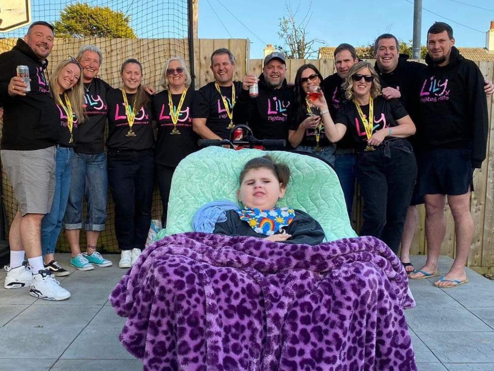 A young mito warrior sitting in front of a group of people wearing Lily Foundation tops