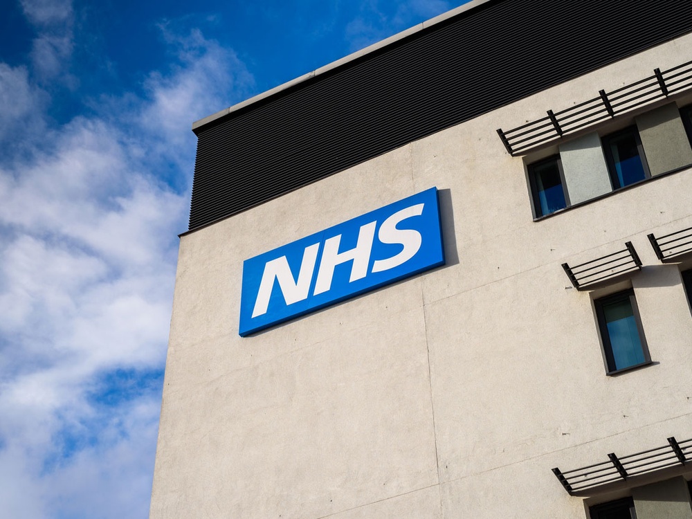 A corner of a building with a sign saying NHS