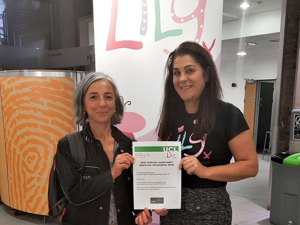 Two women stand in front of a Lily Foundation bannor