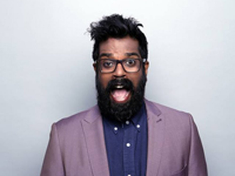 Romesh Ranganathan in a lilac suit and blue shirt