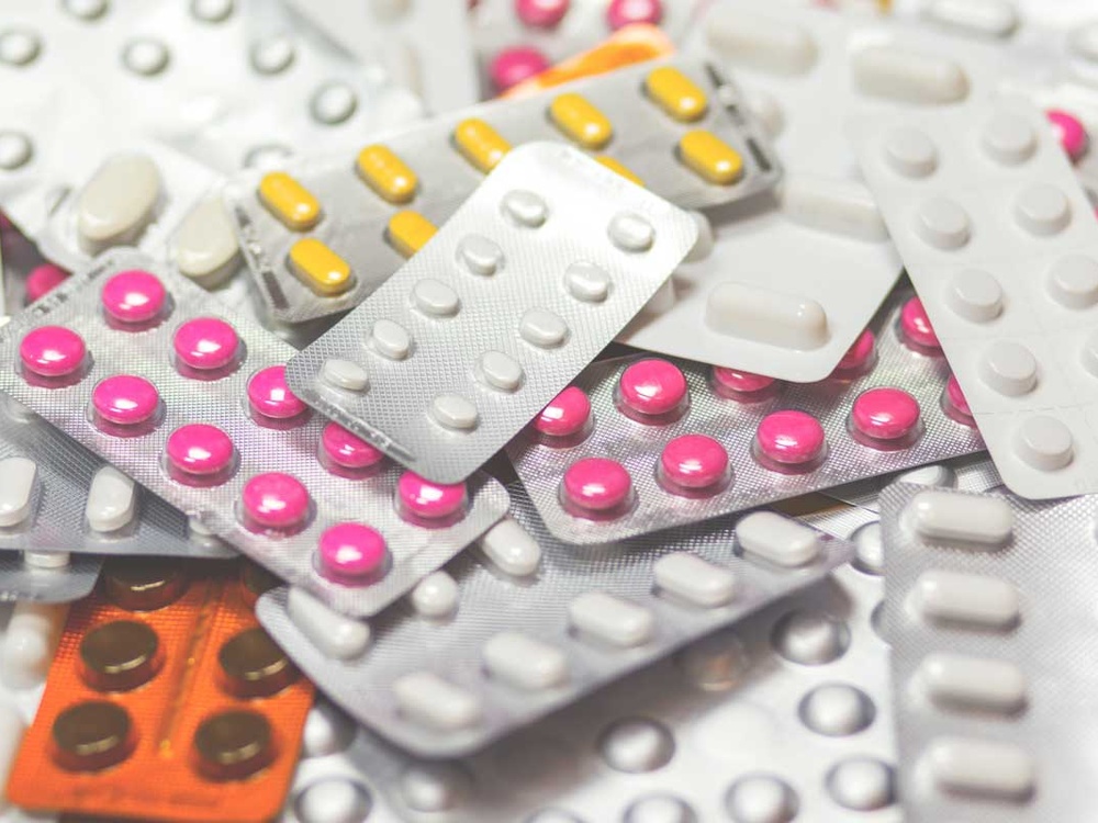 a pile of various type of pills in blister packs