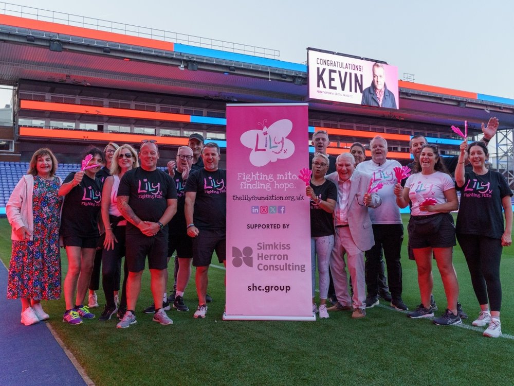 Kevin Day and supporters standing around a pink Lily Foundation banner