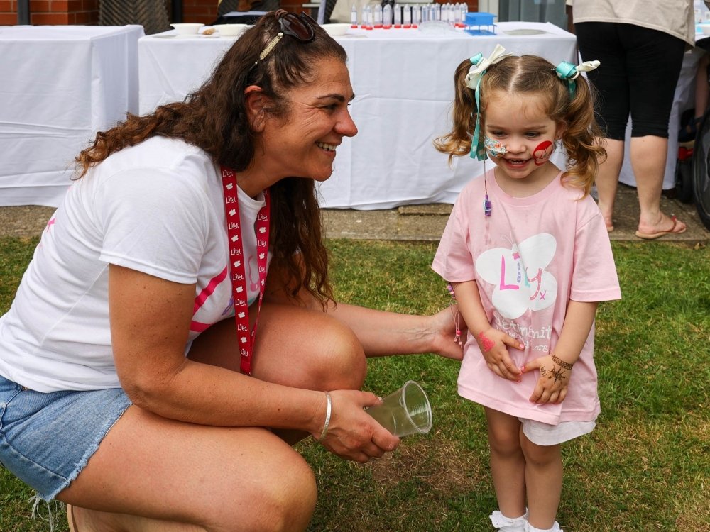 Lily founder Liz at the Family Weekend bending down to talk to a young girl