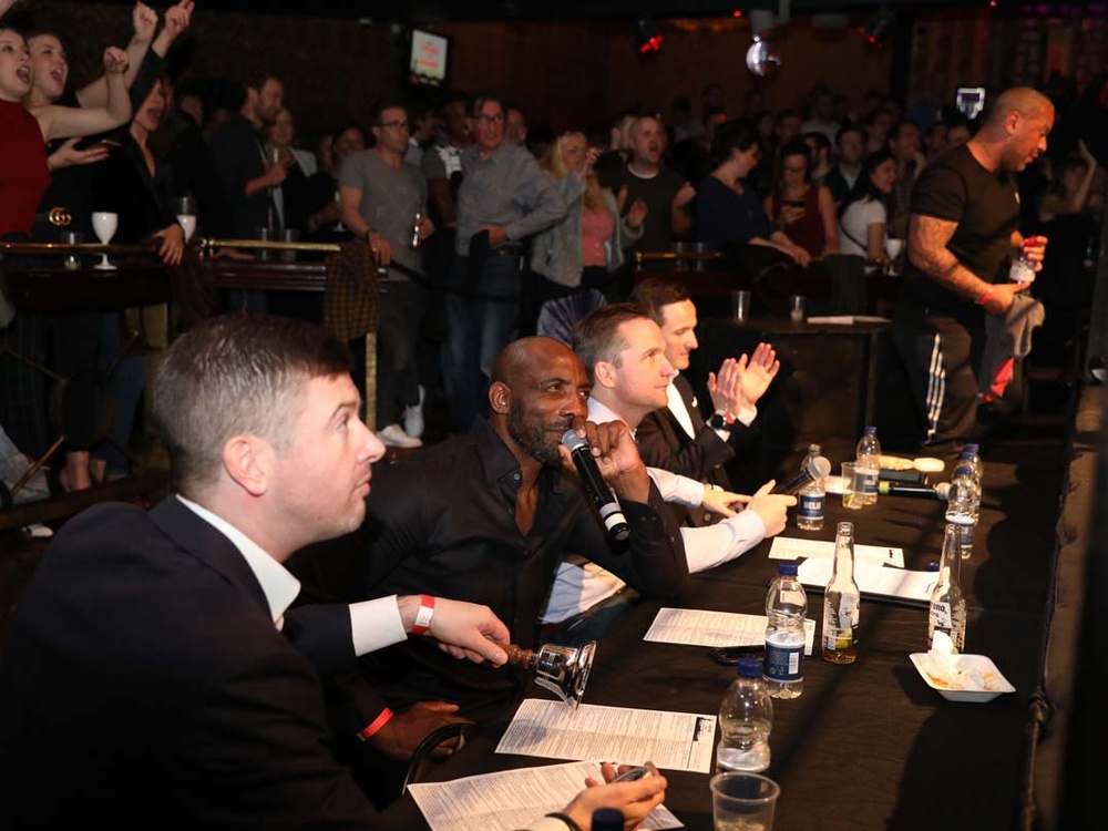 Commentators at the Clapham Grand seated at a table