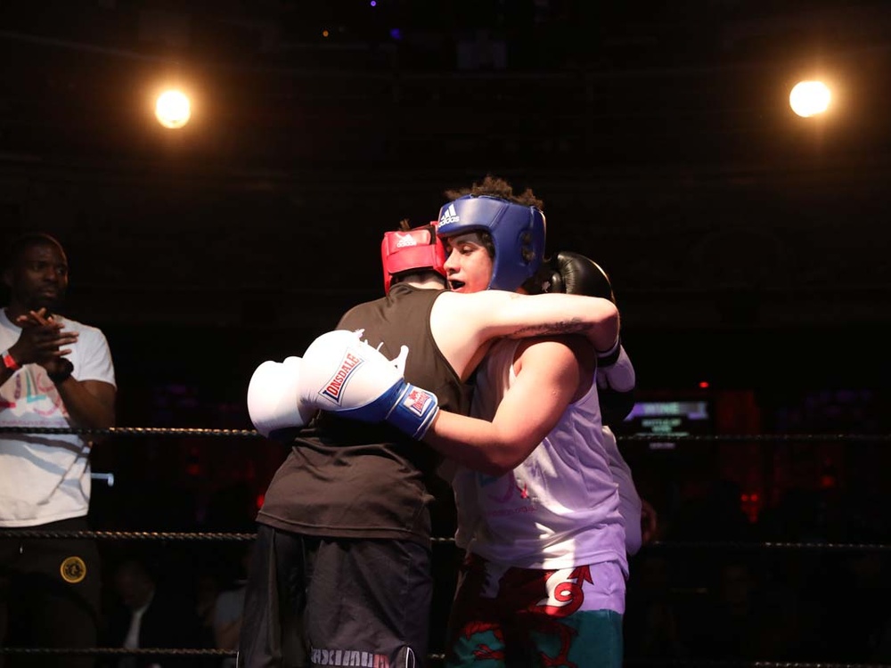 Two boxers in the ring embracing one another