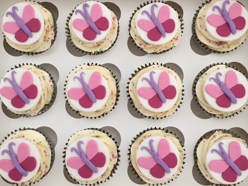Overhead of cupcakes decorated with Lily Foundation butterflies