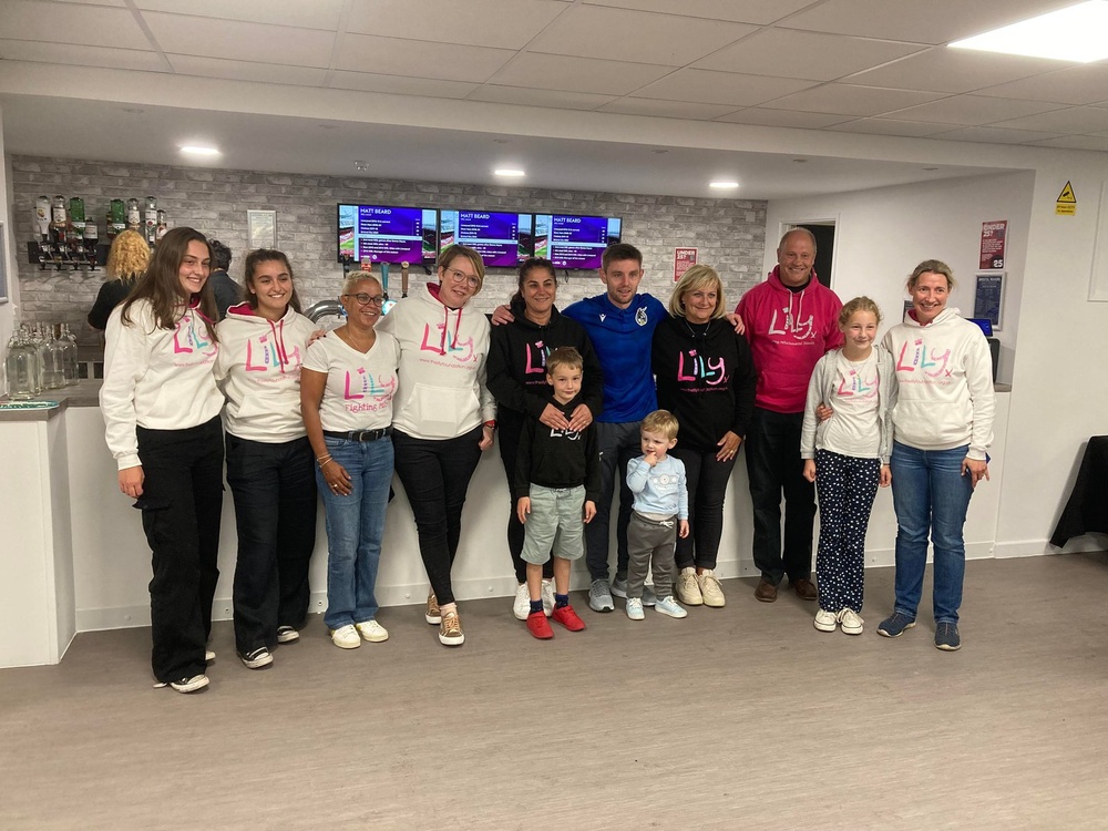 A group of people standing together indoors wearing Lily Foundation tops