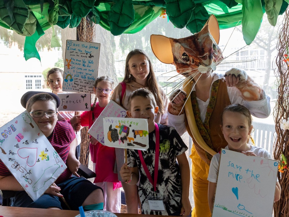 A group of children holding up pictures they've painted