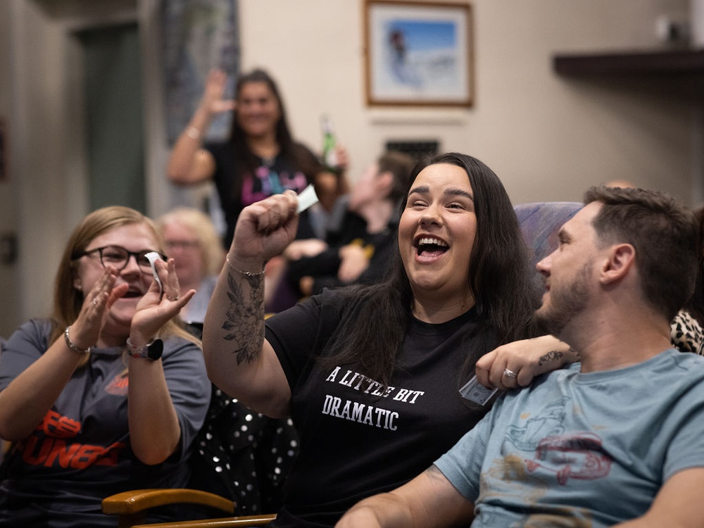 Three young people laughing and clapping together