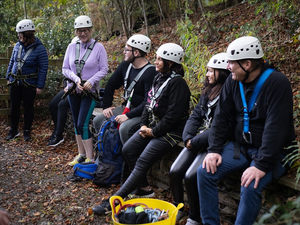 A group of young adult mito patients outdoors wearing hard hats and harnesses