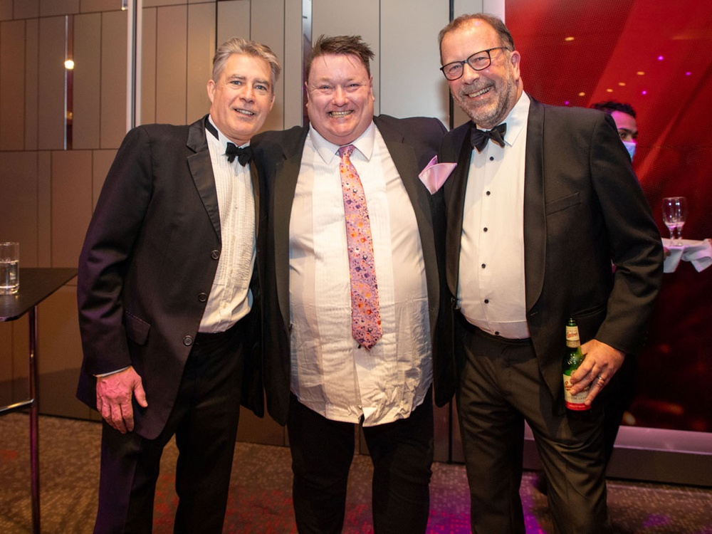 Three men in tuxedos at the Lily charity ball