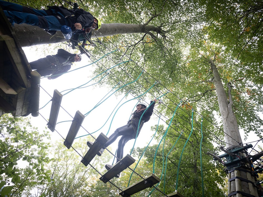 Young adult mito patients crossing a treetop trek at the Calvert Trust