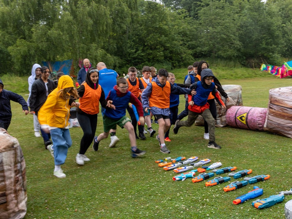 A group of children outside running on the grass