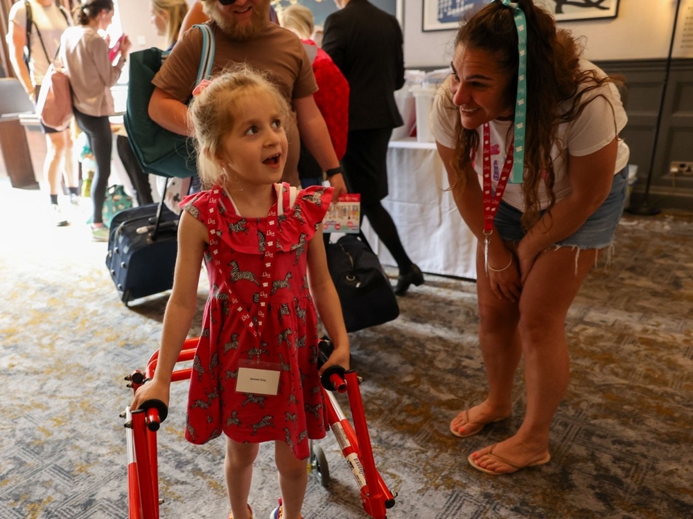 A young girl with a walking frame smiling and laughing